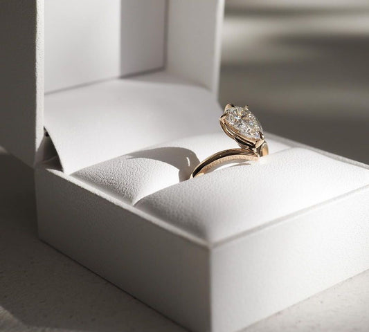 2ct Pear Cut Lab Grown Diamond Solitaire Ring Luxurious diamondWeb Translate News blog post ring ceremony Article Life Money 2025 design Ring Ceremony Diamond Shape Diamond Ring Surat Diamond India Market Diamond Ring for Her Diamond Ring for Men Diamond Ring Women Engagement Ring Finger For Her Finger Ring Gold Ring Bluestone Ring Diamond Ring Price Gold Ring Price Close-up of an exquisite gold-band ring featuring a diamond, ideal for engagement celebrations or luxury jewelry enthusiasts. The soft manicure