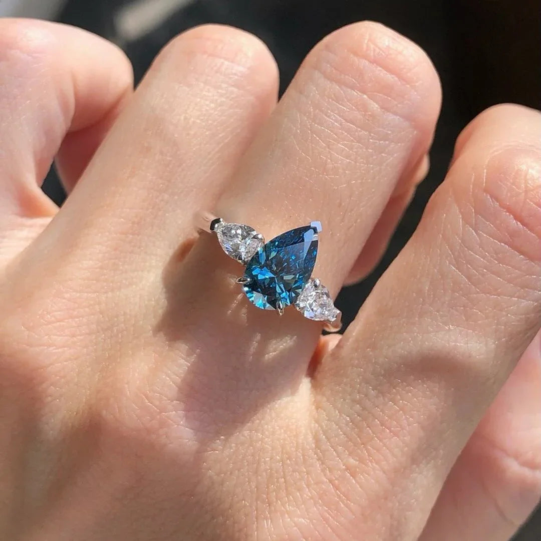 Pear shaped blue lab created diamond engagement ring, three stone setting, white pear side stones, IGI certified, ethical bridal jewelry