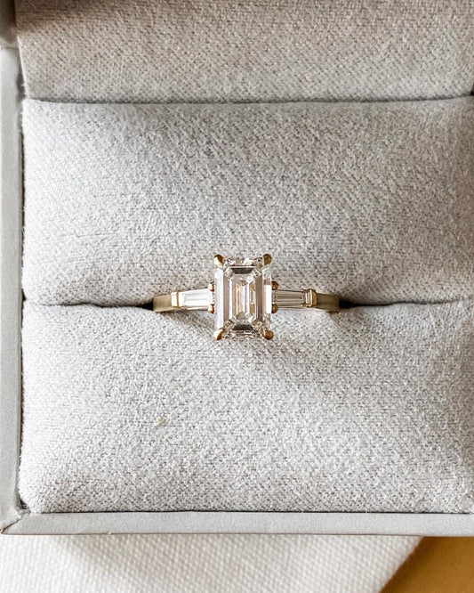 3ct Emerald Center Stone With Two Side Stone Lab Grown Diamond Ring  The hand displays a soft, natural manicure, highlighting the diamond's brilliance and the ring's refined craftsmanship. Ideal for those seeking timeless, high-end accessories for special occasions. YouTube Amazon Facebook Weather Google Gmail Wordless WhatsApp Web Translate News blog post ring ceremony Article Life Money 2025 design Ring Ceremony Diamond Shape Diamond Ring Surat Diamond India Market Diamond Ring for Her Diamond Ring for 