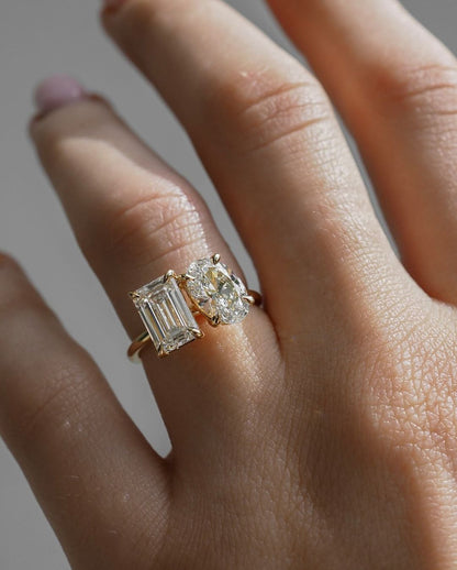 6tcw Emerald and Oval Cut Toi et Moi Lab Grown Diamond Ring Close-up of an exquisite gold-band ring featuring a diamond, ideal for engagement celebrations or luxury jewelry enthusiasts. The soft manicure enhances the refined and elegant appeal. YouTube Amazon Facebook Weather Google Gmail Wordless WhatsApp Web Translate News blog post ring ceremony Article Life Money 2025 design Ring Ceremony Diamond Shape Diamond Ring Surat Diamond India Market Diamond Ring for Her Diamond Ring for Men Diamond Ring Women 