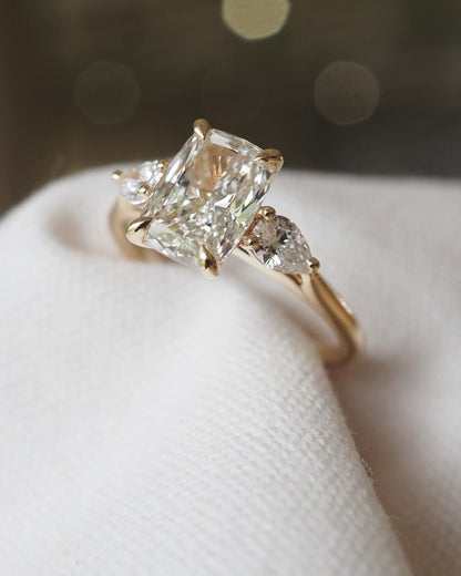 4ct Cushion Cut Center Diamond With Two Side Pear Cut Lab Grown Diamond Ring Close-up of an exquisite gold-band ring featuring a diamond, ideal for engagement celebrations or luxury jewelry enthusiasts. The soft manicure enhances the refined and elegant appeal. YouTube Amazon Facebook Weather Google Gmail Wordless WhatsApp Web Translate News blog post ring ceremony Article Life Money 2025 design Ring Ceremony Diamond Shape Diamond Ring Surat Diamond India Market Diamond Ring for Her Diamond Ring for Men 