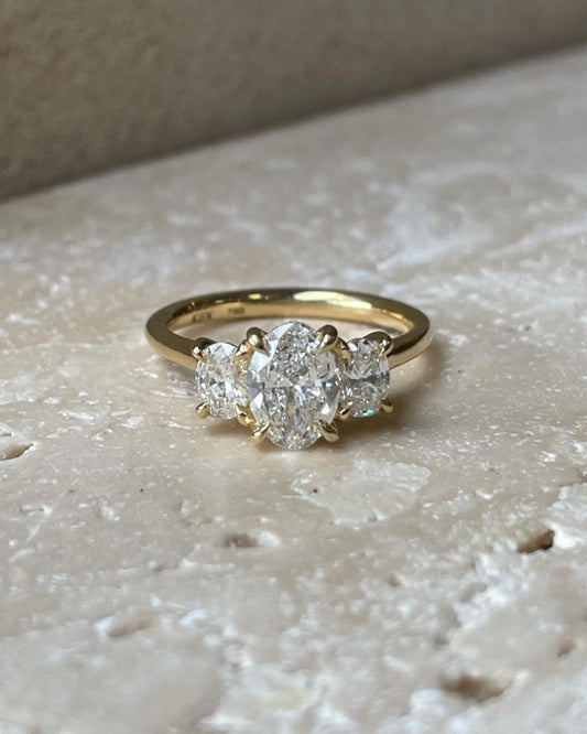 1.5ct Oval Trio Lab Grown Diamond Ring wedding Set Three Stone  Close-up of an exquisite gold-band ring featuring a diamond, ideal for engagement celebrations or luxury jewelry enthusiasts. The soft manicure enhances the refined and elegant appeal. YouTube Amazon Facebook Weather Google Gmail Wordless WhatsApp Web Translate News blog post ring ceremony Article Life Money 2025 design Ring Ceremony Diamond Shape Diamond Ring Surat Diamond India Market Diamond Ring for Her Diamond Ring for Men Diamond Ring 