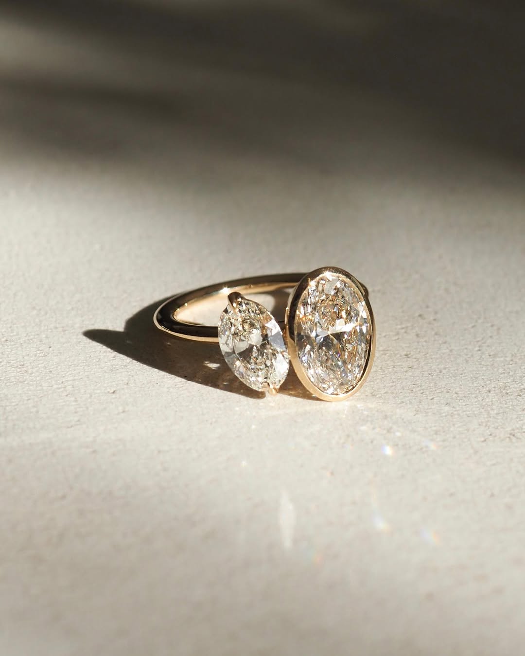 1.5ct Duet Oval Full Bezel Diamond Ring Toi et Moi  The hand displays a soft, natural manicure, highlighting the diamond's brilliance and the ring's refined craftsmanship. Ideal for those seeking timeless, high-end accessories for special occasions.  The hand displays a soft, natural manicure, highlighting the diamond's brilliance and the ring's refined craftsmanship. Ideal for those seeking timeless, high-end accessories for special occasions.