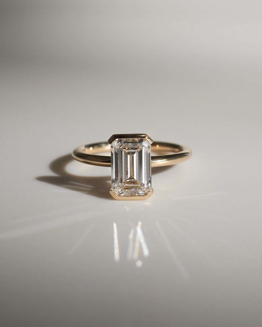 4.5ct Emerald Cut Half Bezel Lab Grown Diamond Ring Close-up of an exquisite gold-band ring featuring a diamond, ideal for engagement celebrations or luxury jewelry enthusiasts. The soft manicure enhances the refined and elegant appeal. YouTube Amazon Facebook Weather Google Gmail Wordless WhatsApp Web Translate News blog post ring ceremony Article Life Money 2025 design Ring Ceremony Diamond Shape Diamond Ring Surat Diamond India Market Diamond Ring for Her Diamond Ring for Men Diamond Ring Women 