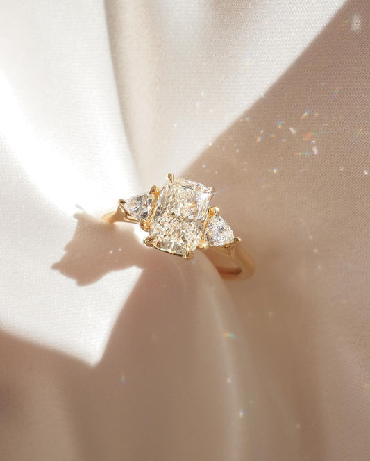 7ct Cushion Cut Lab Grown Diamond Trio Ring With Center Stone With Pear Side Stones This stunning diamond ring, set on a timeless gold band, combines elegance and modern design. Its radiant, carefully crafted diamond centerpiece captures light beautifully, making it the perfect symbol of love and commitment. YouTube Amazon Facebook Weather Google Gmail Wordless WhatsApp Web Translate News blog post ring ceremony Article Life Money 2025 design Ring Ceremony Diamond Shape Diamond Ring Surat Diamond India Mark