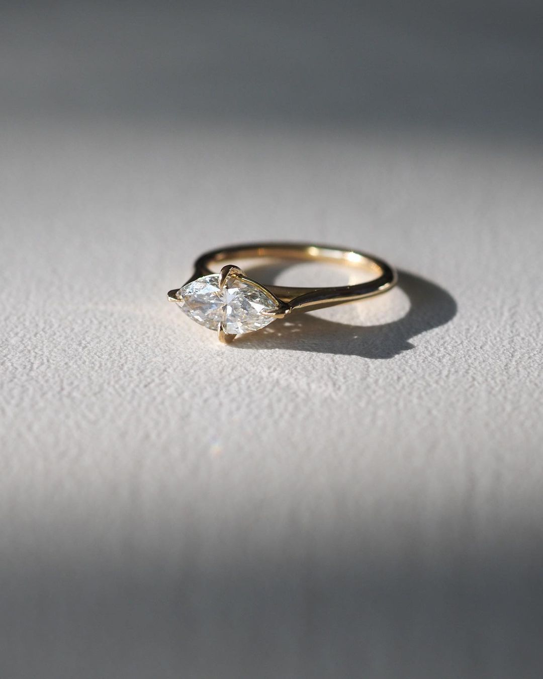 1.5ct Marquise Solitaire Lab Grown Diamond Ring Close-up of an exquisite gold-band ring featuring a diamond, ideal for engagement celebrations or luxury jewelry enthusiasts. The soft manicure enhances the refined and elegant appeal. Women Engagement Ring Finger For Her Finger Ring Gold Ring Bluestone Ring Diamond Ring Price Gold Ring Price