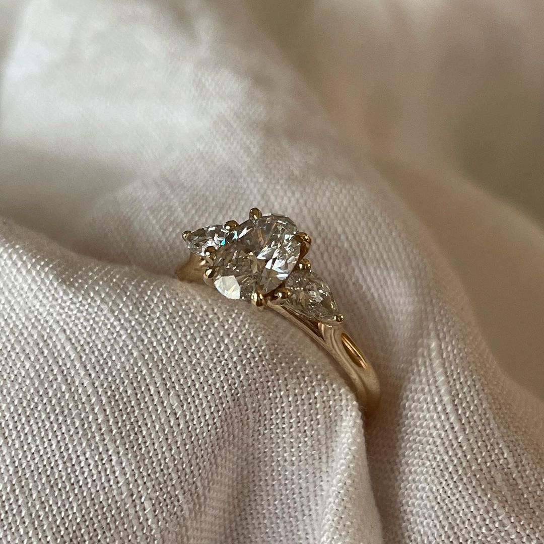 1.2ct Oval Lab Grown Diamond With Shoulder Stone Ring Minimalist Engagement Ring and wedding gift or Birthday Gift her/women Luxurious diamond engagement ring on a gold band, elegantly showcased on a well-manicured hand for wedding and proposal inspiration.